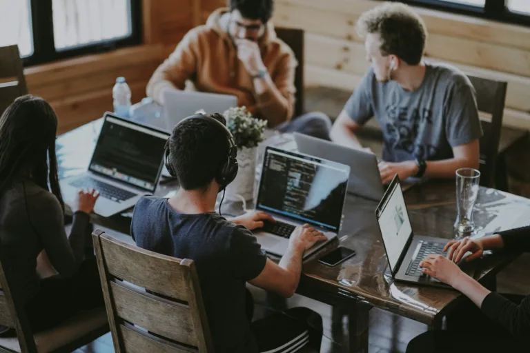 Grupo de Pessoas com Laptops na Mesa